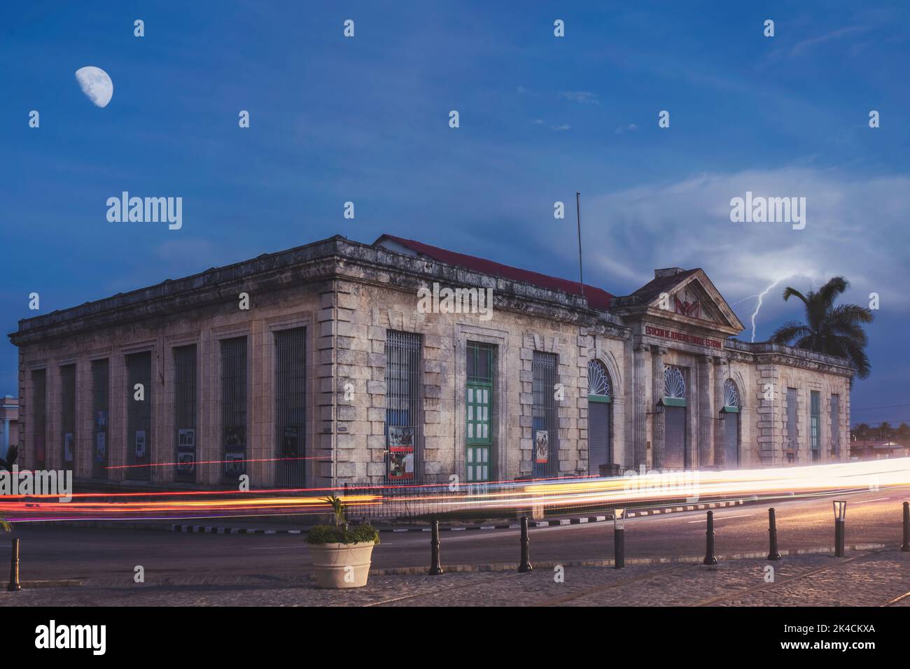 Une longue exposition de sentiers lumineux près d'un ancien bâtiment sous la lune Banque D'Images