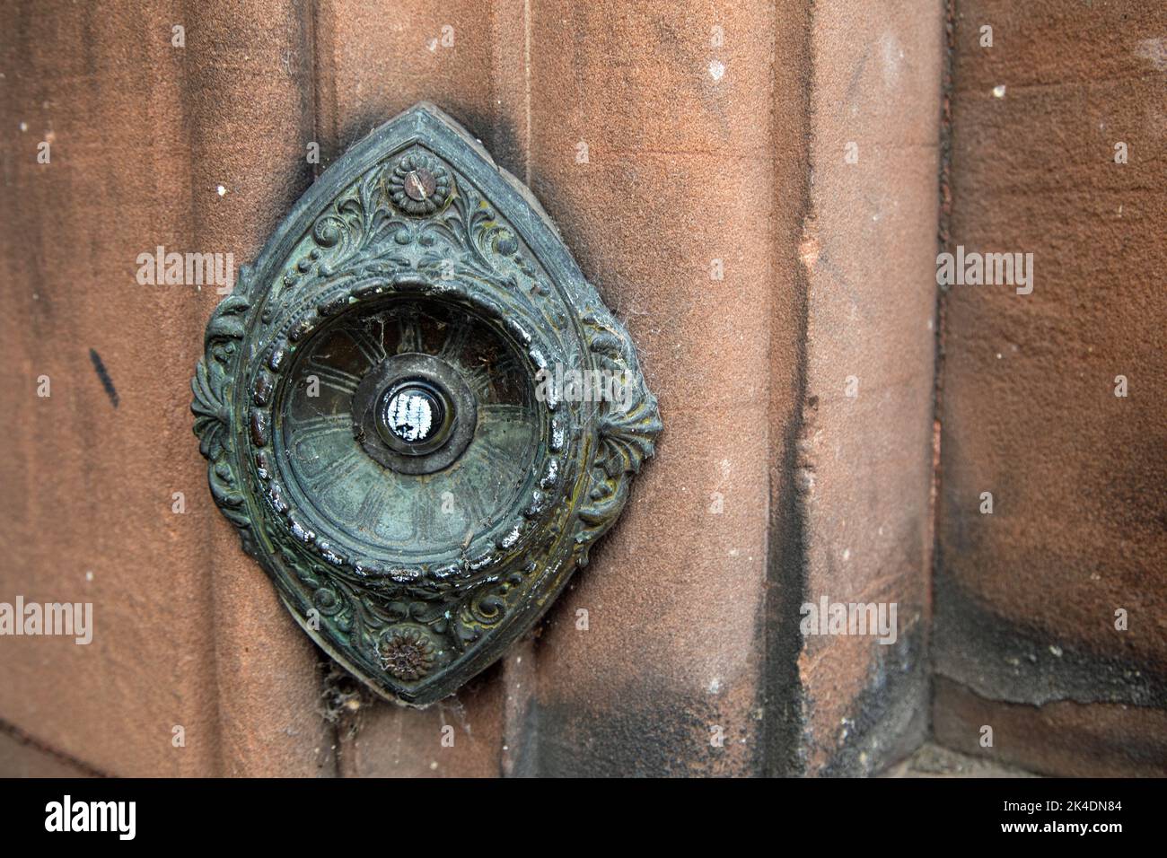 Bouton de cloche de porte électrique en bronze fin 19th siècle/début 20th siècle dans un mur en grès rouge Banque D'Images