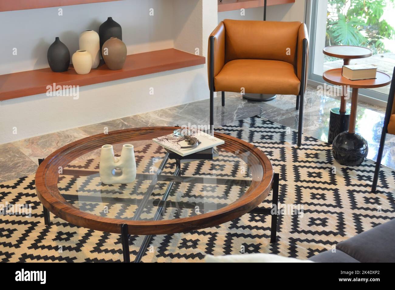 Double table en bois brun, avec bords métalliques circulaires et plusieurs étagères en verre. Banque D'Images