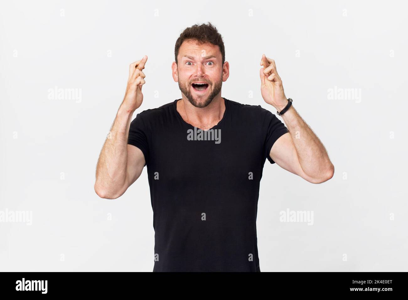 Souriant positif homme avec un look attrayant souhaitant bonne chance posant sur fond blanc Banque D'Images