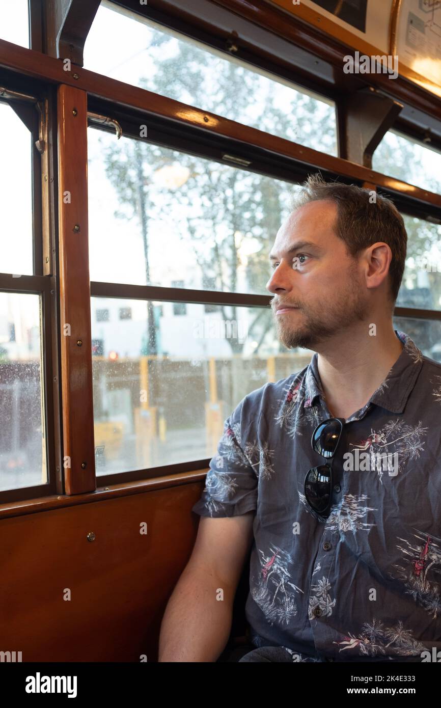 Un homme assis dans un célèbre tramway historique de la classe W de Melbourne, en regardant par la fenêtre Banque D'Images