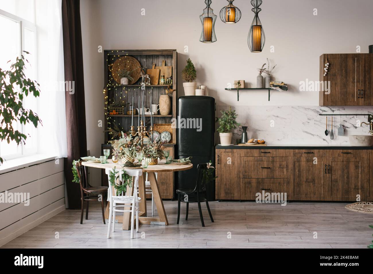 Salon ou cuisine intérieur avec une table ronde et une variété de chaises dans une maison de campagne décorée pour Noël et le nouvel an Banque D'Images