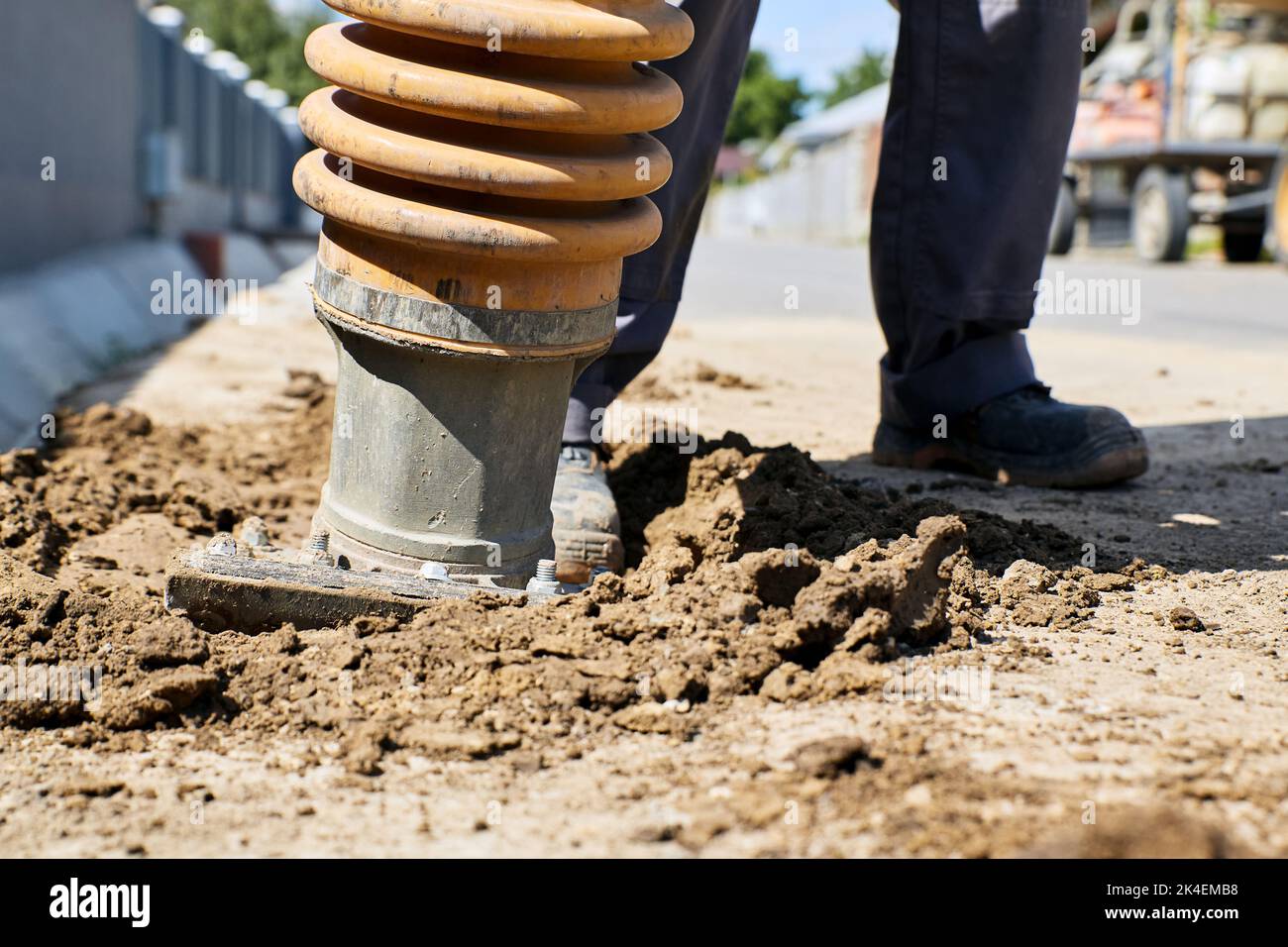 Travailleur utilisant un compacteur de sol sur le chantier de construction Banque D'Images