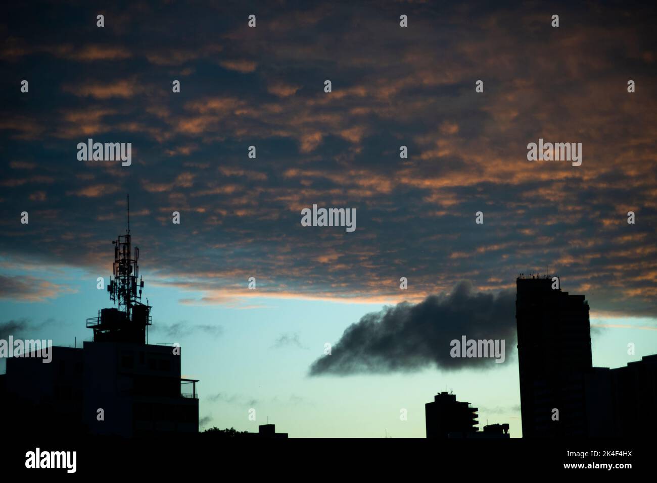 Silhouette de bâtiment et antennes électriques contre le coucher de soleil spectaculaire de couleur bleue. Des nuages chargés et spectaculaires. Belle fin d'après-midi. Salvador Banque D'Images