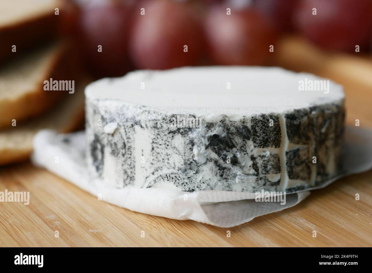 fromage de chèvre frais et fruits de raisin sur fond de bois. Banque D'Images