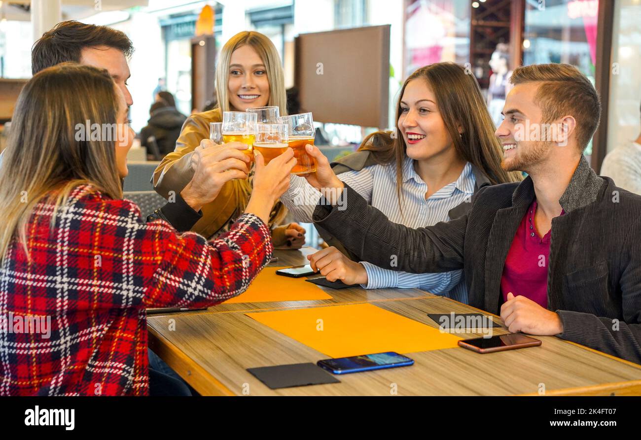 Groupe de personnes accrochées les unes aux autres dans un bar et applaudisant avec de la bière - amis appréciant le temps de fiendship et de parler les uns avec les autres heureux - Lifestyl Banque D'Images