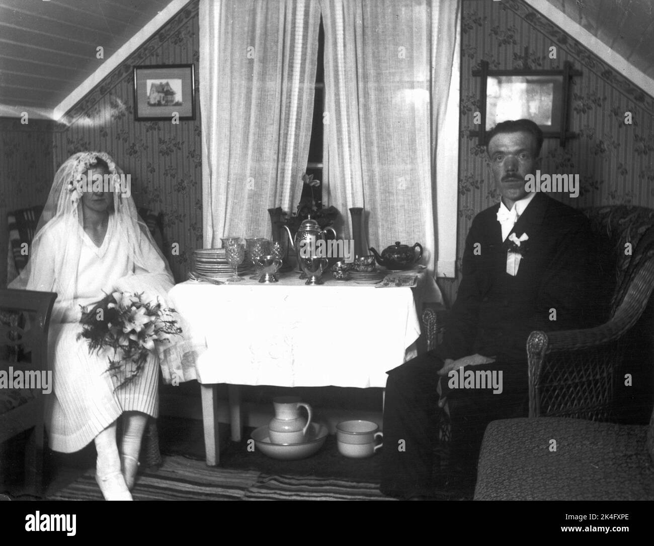 Mariée et marié assis de chaque côté d'une table avec des cadeaux de mariage. Pays nordiques Banque D'Images