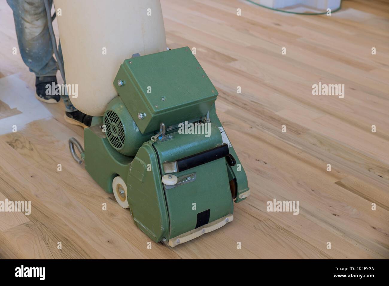 Le procédé de meulage d'un parquet en bois en utilisant une ponceuse de plancher de la maison nouvellement construite Banque D'Images