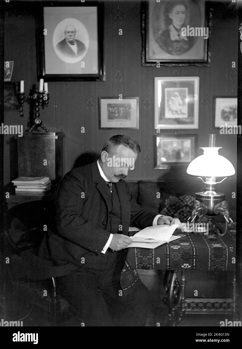 Dr. Julius Levenhagen à la table avec un livre. Lampe à paraffine. Pays nordiques Banque D'Images