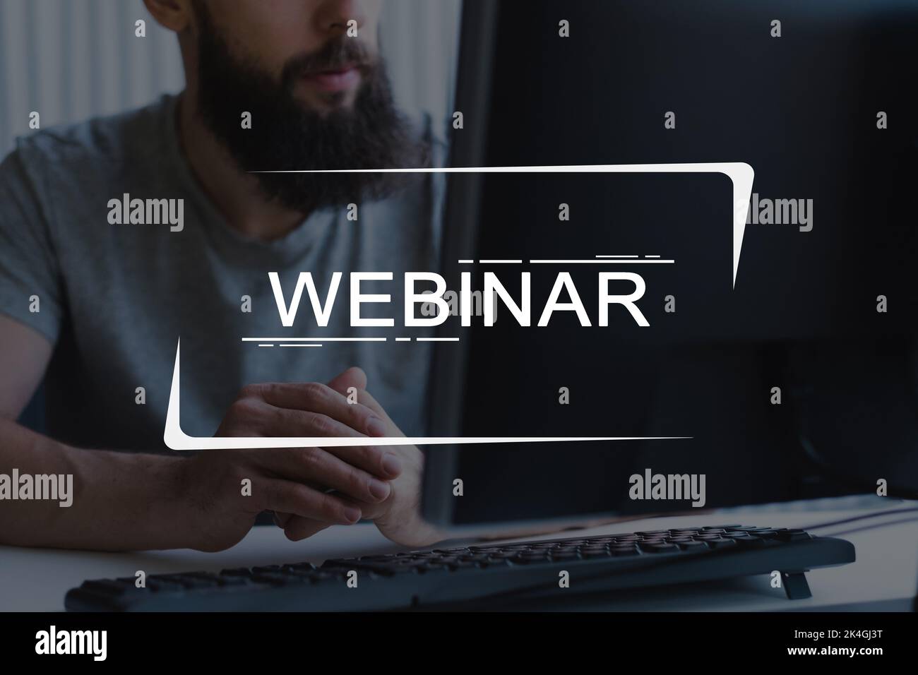 Formation en ligne. Formation virtuelle. Enseignement à distance. IL cours. Homme barbu méconnaissable regardant une leçon vidéo sur un pc sur le lieu de travail avec t Banque D'Images