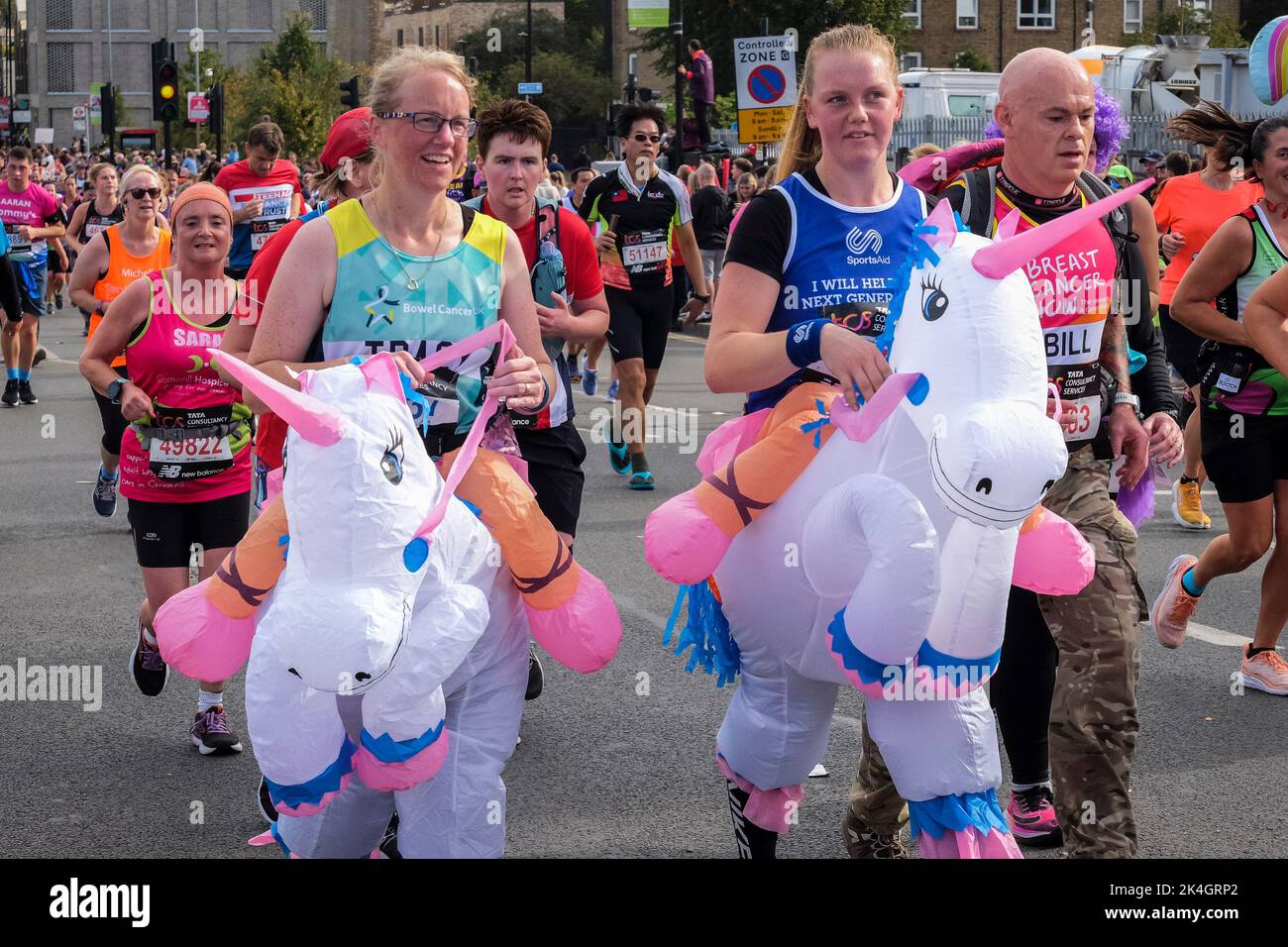 Londres, Royaume-Uni, 2nd octobre 2022. Plus de 40 000 participants s'emprennent dans les rues de la capitale pour le Marathon de Londres 42nd. L'événement qui attire des coureurs d'élite et des athlètes en fauteuil roulant permet également de relever des millions de livres pour la charité grâce à la participation de coureurs de club et de fitness ainsi que ceux qui veulent juste relever le défi de 26 miles. Deux coureurs avec des licornes gonflables participent au marathon de Londres. Banque D'Images