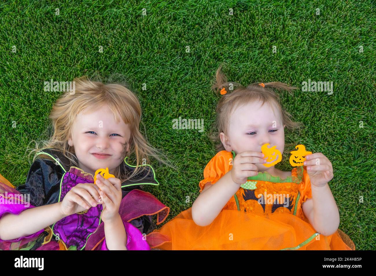 Drôle de petits enfants à Halloween vêtus d'un costume de sorcière et de citrouille à l'extérieur. Halloween, vacances et concept d'enfance. Banque D'Images