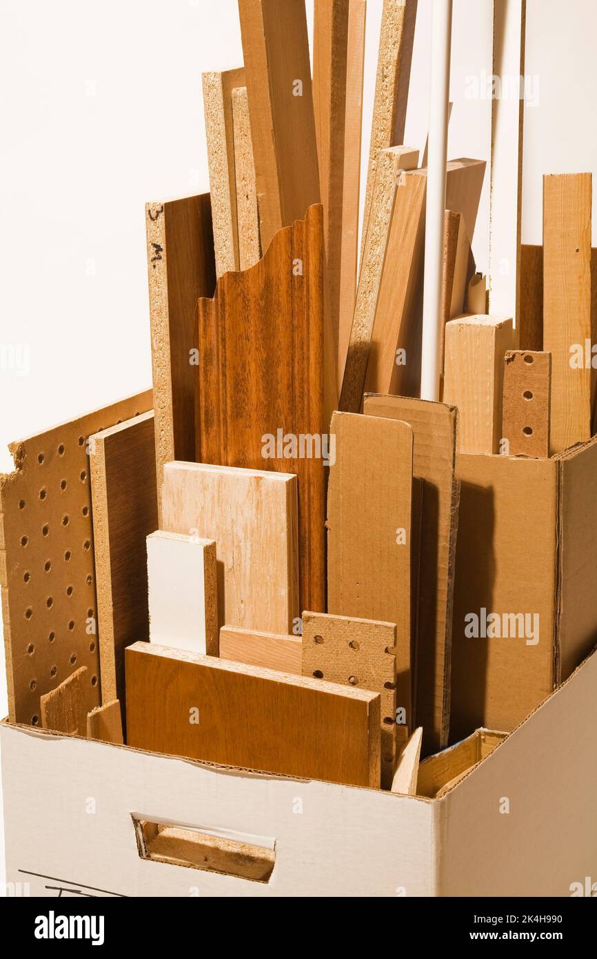 Boîte en carton remplie de différentes tailles et sortes de morceaux de bois. Banque D'Images