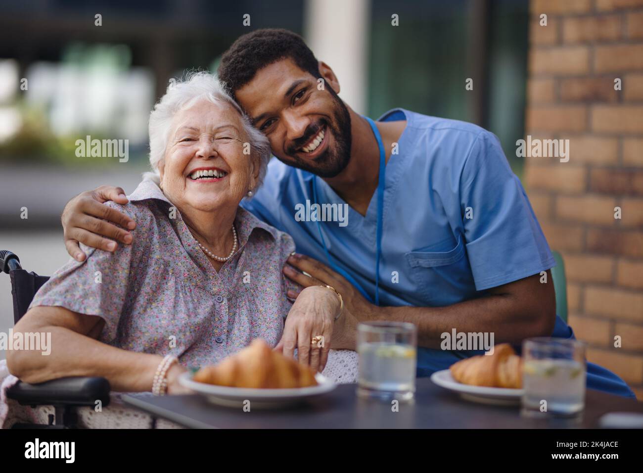 Soignant prenant le petit déjeuner avec son client au café. Banque D'Images