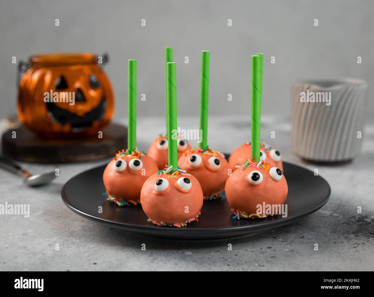 Halloween gâteau POPS avec visages drôles sur l'assiette sombre Banque D'Images