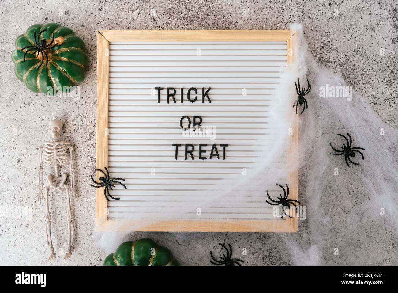 Joyeux halloween concept de vacances. Squelettes, araignée, toile, citrouille, trick ou traiter le texte sur le cadre de la carte sur fond gris en béton. Fête d'Halloween Banque D'Images