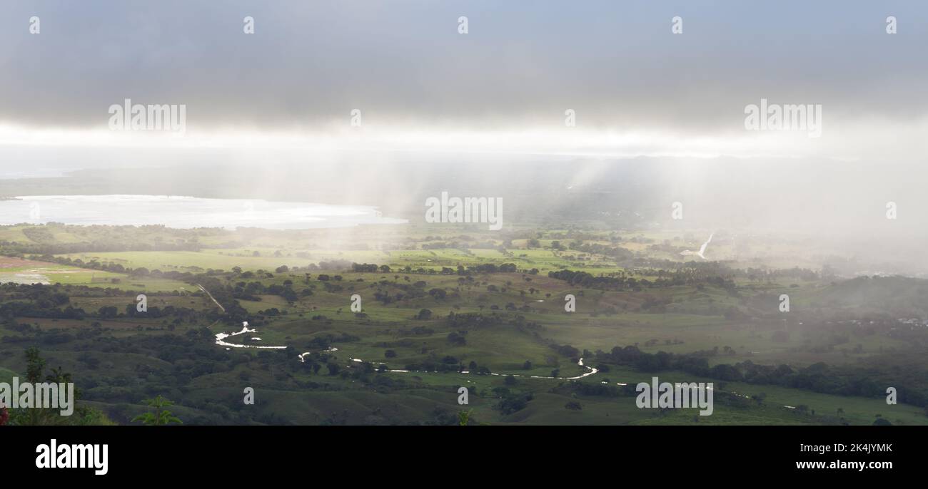 Paysage panoramique avec vallée sous ciel nuageux sur une matinée pluvieuse et ensoleillée. Photo naturelle prise sur le sommet de Montana Redonda, République Dominicaine Banque D'Images