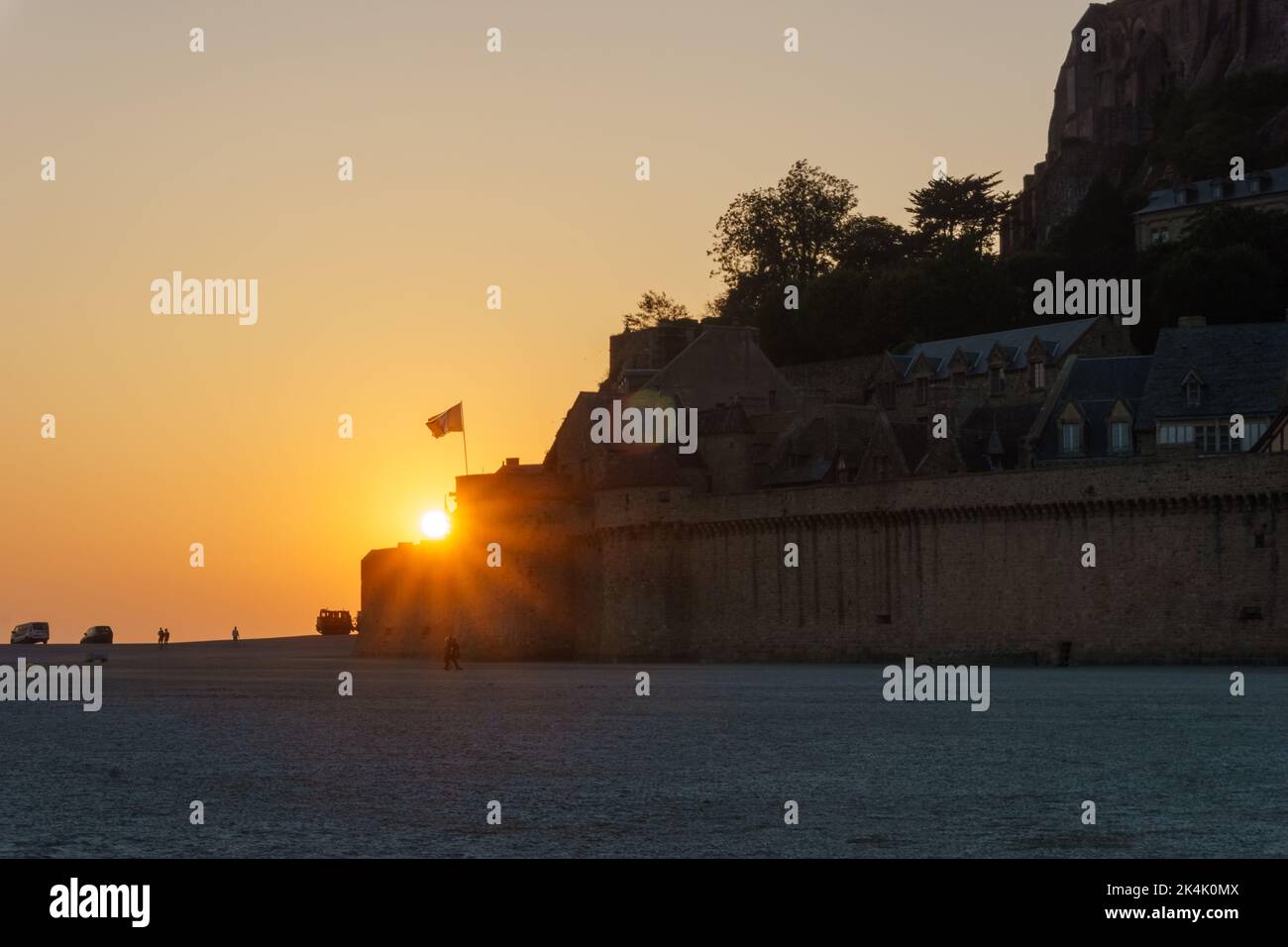 Soleil sur l'entrée du Mont Saint Michel au coucher du soleil à marée basse lors d'une soirée d'été, Normandie, France Banque D'Images