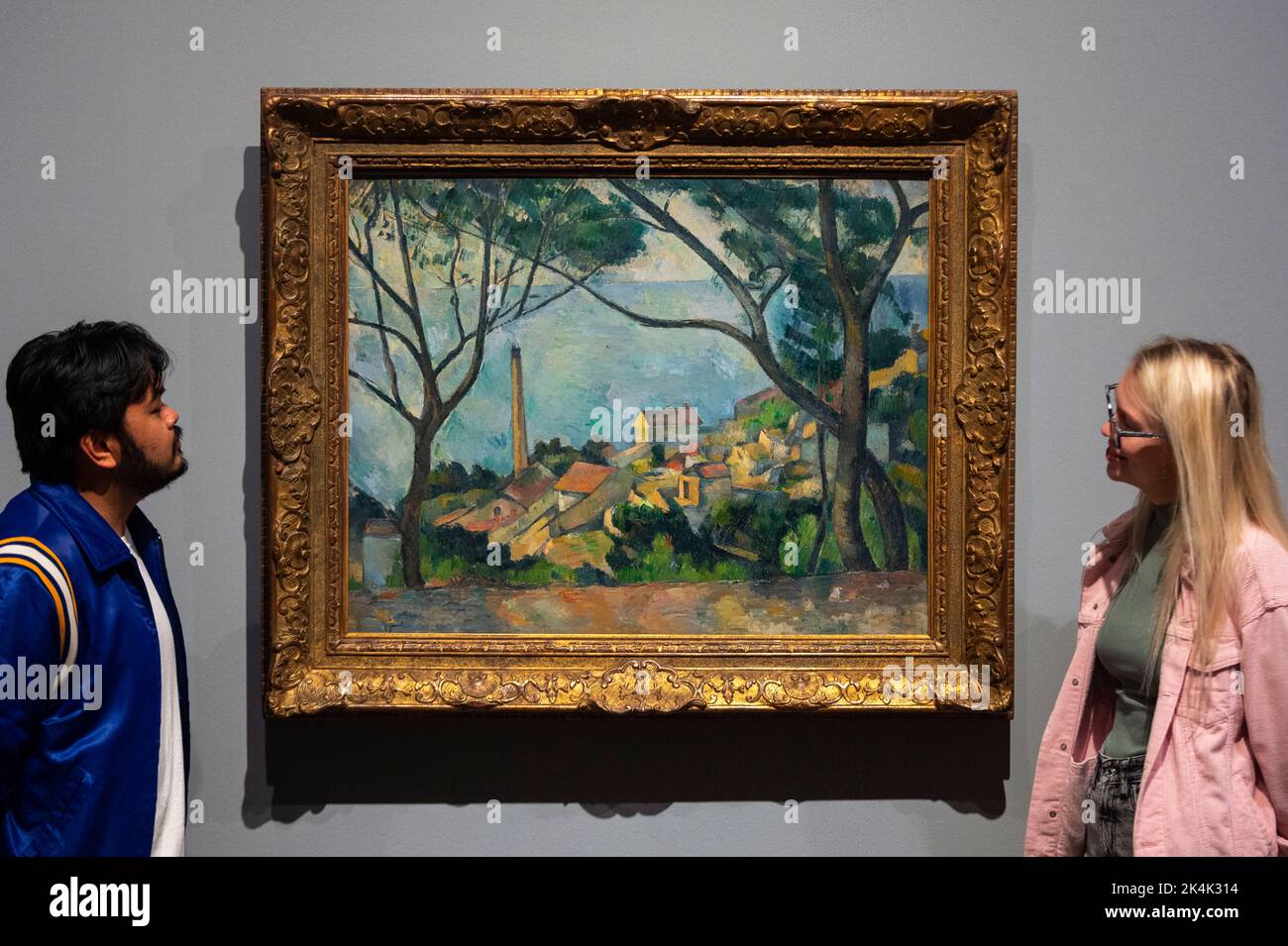 Londres, Royaume-Uni. 3 octobre 2022. Les membres du personnel ont une vue sur « la mer à l'Estaque derrière les arbres », 1878-9, par Paul Cézanne à l'avant-première de l'exposition EY : Cézanne à Tate Modern. 80 peintures, aquarelles et dessins de Paul Cezanne présentant des exemples clés de ses peintures emblématiques de la vie, des paysages provençaux, des portraits et des scènes de plumes, dont plus de 20 œuvres jamais vues au Royaume-Uni, sont exposés du 5 octobre au 12 mars 2023. Credit: Stephen Chung / Alamy Live News Banque D'Images