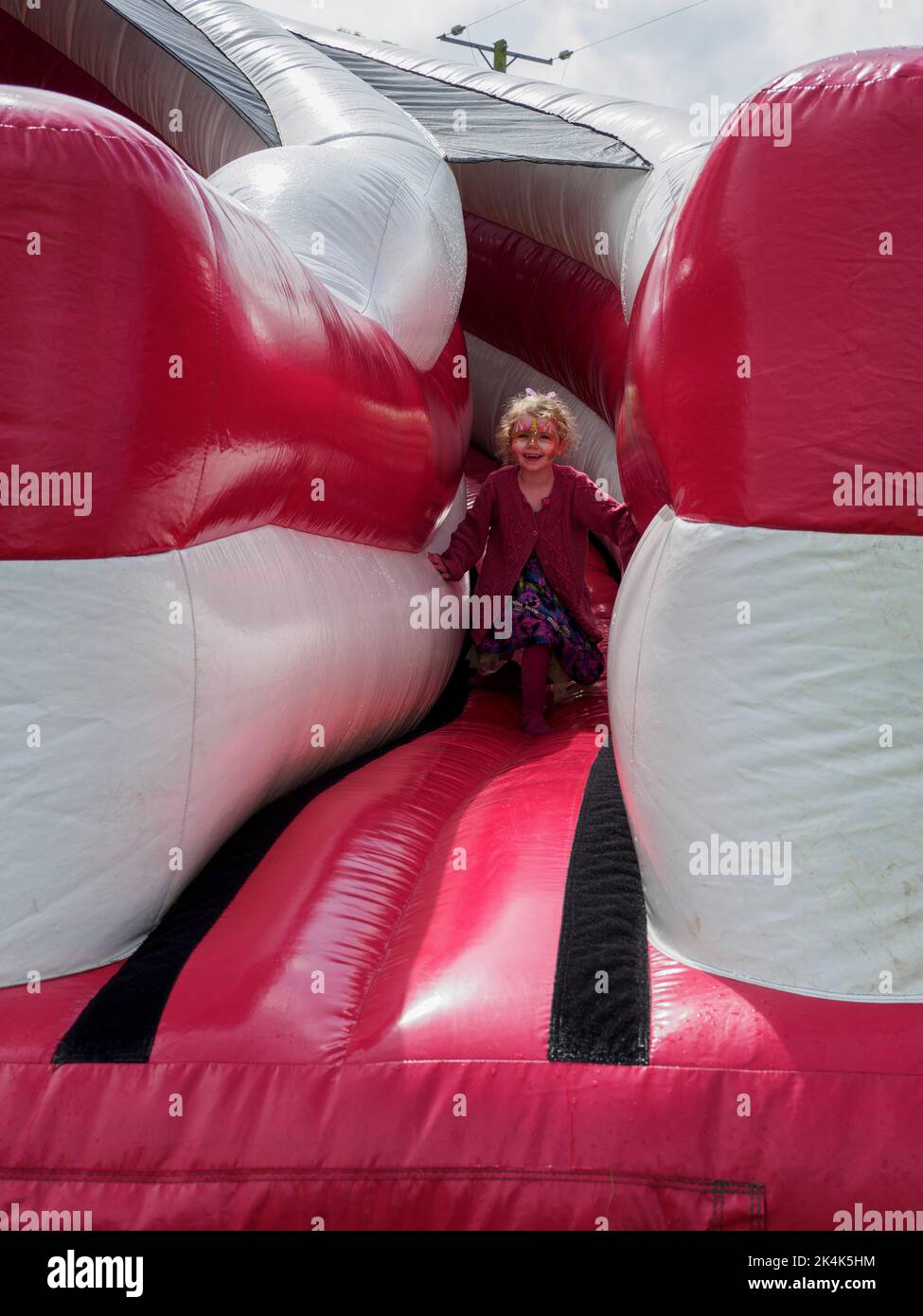 Jeune enfant glissant sur une grande glissade, Royaume-Uni Banque D'Images
