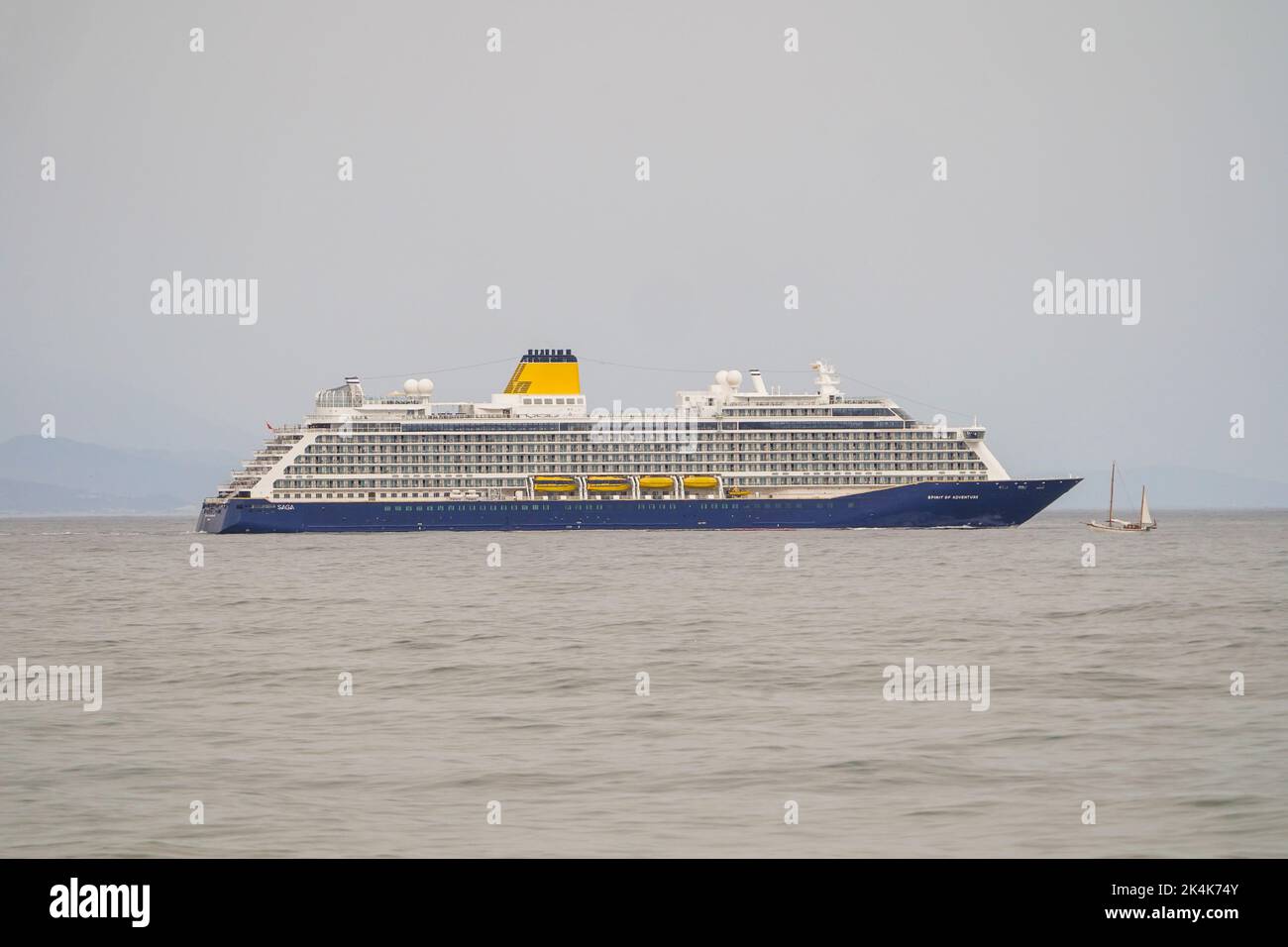 Spirit of Adventure, bateau de croisière exploité par Saga, traversant un petit voilier d'époque, sur la mer ouverte, Malaga. Espagne Banque D'Images