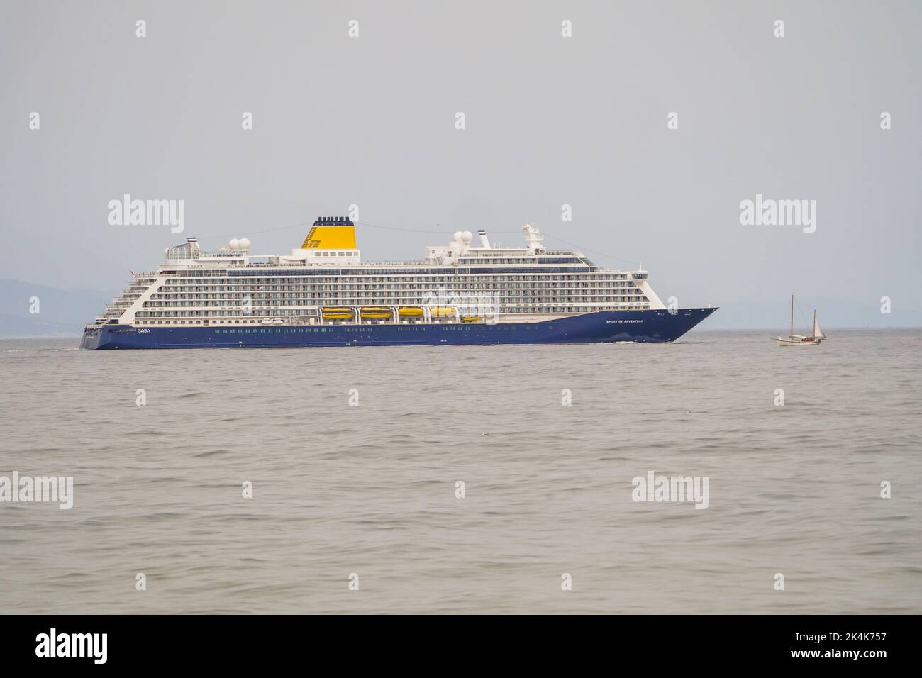 Spirit of Adventure, bateau de croisière exploité par Saga, traversant un petit voilier d'époque, sur la mer ouverte, Malaga. Espagne Banque D'Images