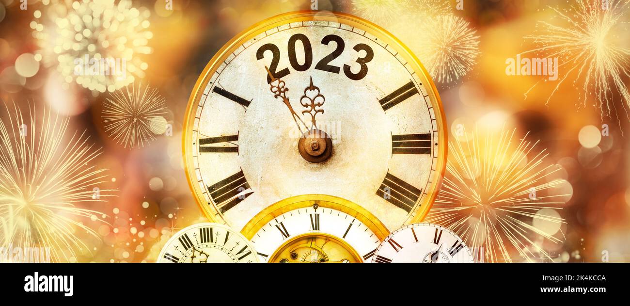Nouvel an 2023 avec feux d'artifice et horloge comptant jusqu'à minuit avec un fond doré défoqué Banque D'Images