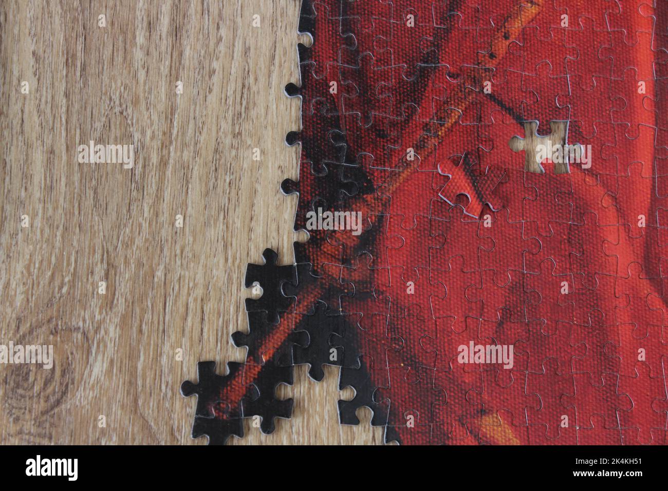Pièces de puzzle rouges sur table en bois avec espace pour le texte. Idée de concept de scie sauteuse. Banque D'Images