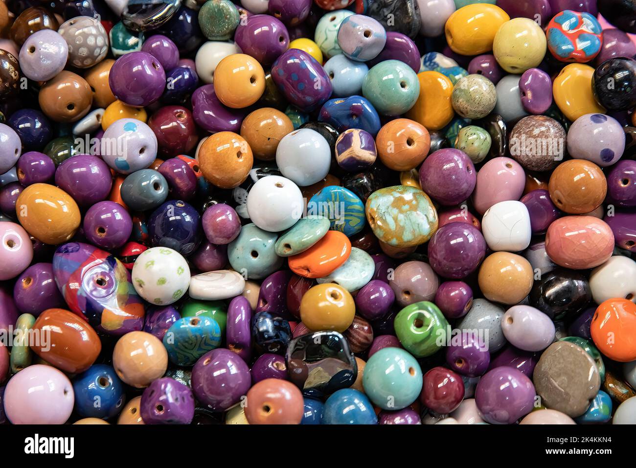 Un fond de perles en céramique vitrifiée colorées. Perles africaines traditionnelles pour bijoux et souvenirs ethniques. Vue de dessus. Banque D'Images