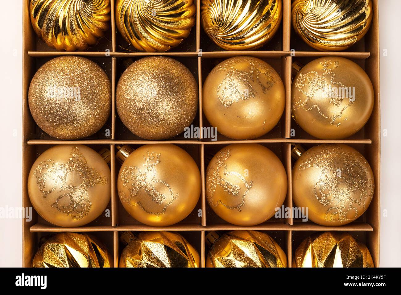 Boules de Noël dorées scintillantes dans une boîte en carton. Vue de dessus Banque D'Images