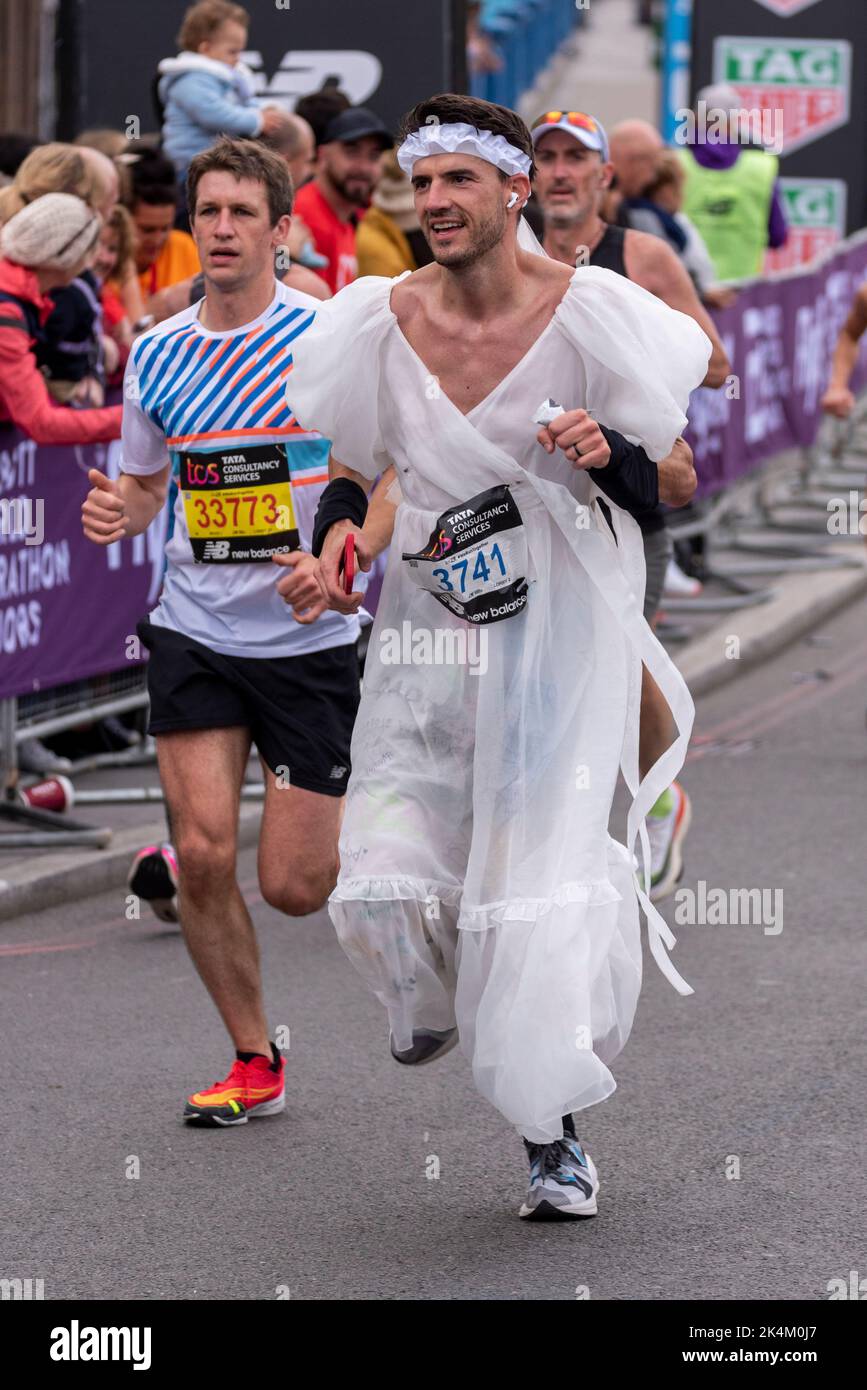 Jordan Maddocks qui s'exécute dans le TCS London Marathon 2022, sur la route d'approche Tower Bridge, City of London, Royaume-Uni, portant la robe de mariage d'une mariée Banque D'Images