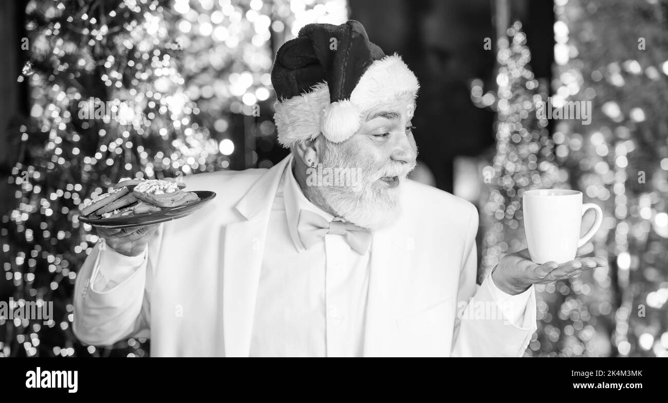 Vacances d'hiver. Grand-père âgé à la maison. Traditions concept. Pause café. Bonbons et gâteries. Le Père Noël près de l'arbre de noël. Joyeux noël Banque D'Images