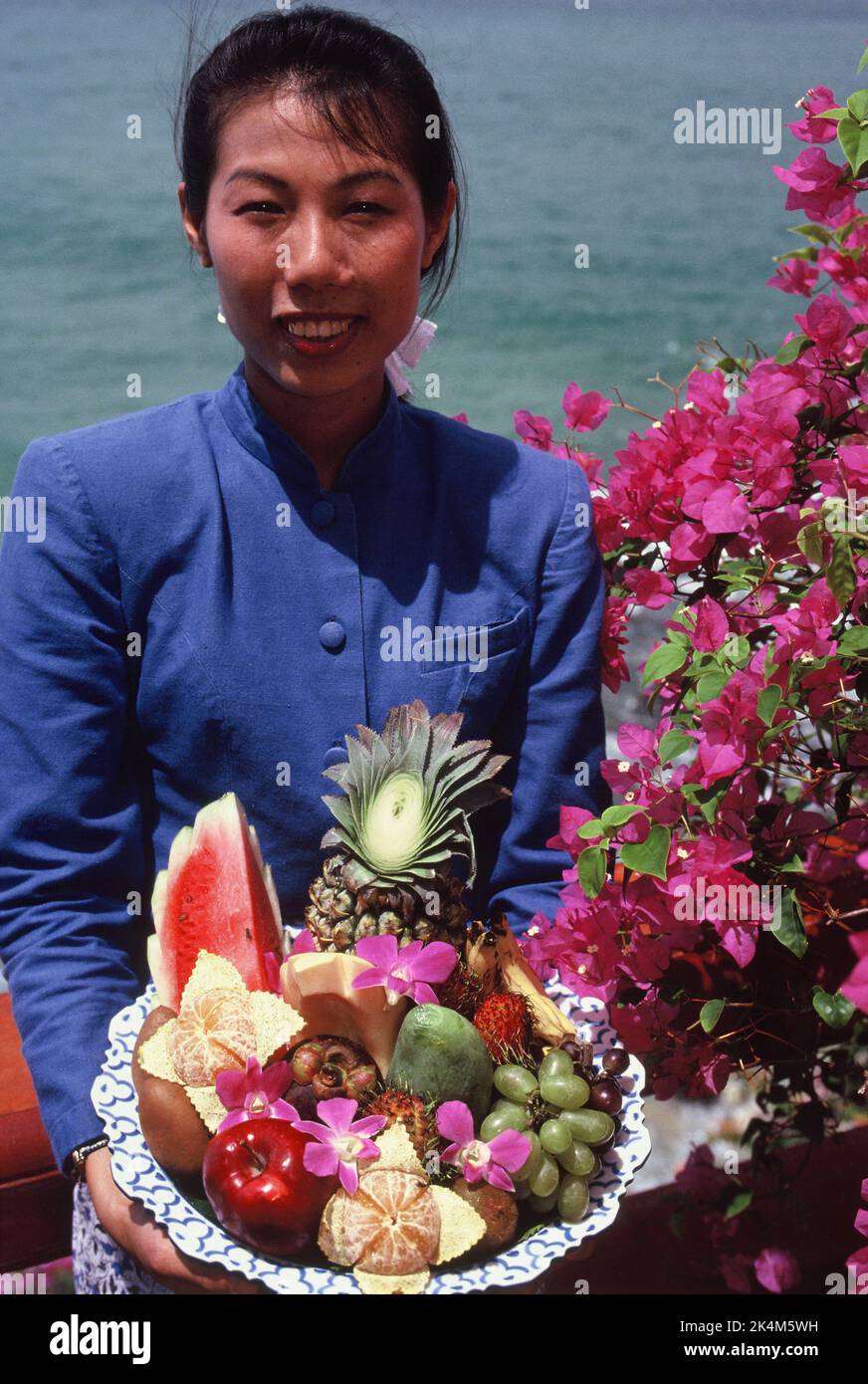 Thaïlande. Yacht Club de Phuket. Jeune femme thaïlandaise tenant un plateau de fruits frais Banque D'Images