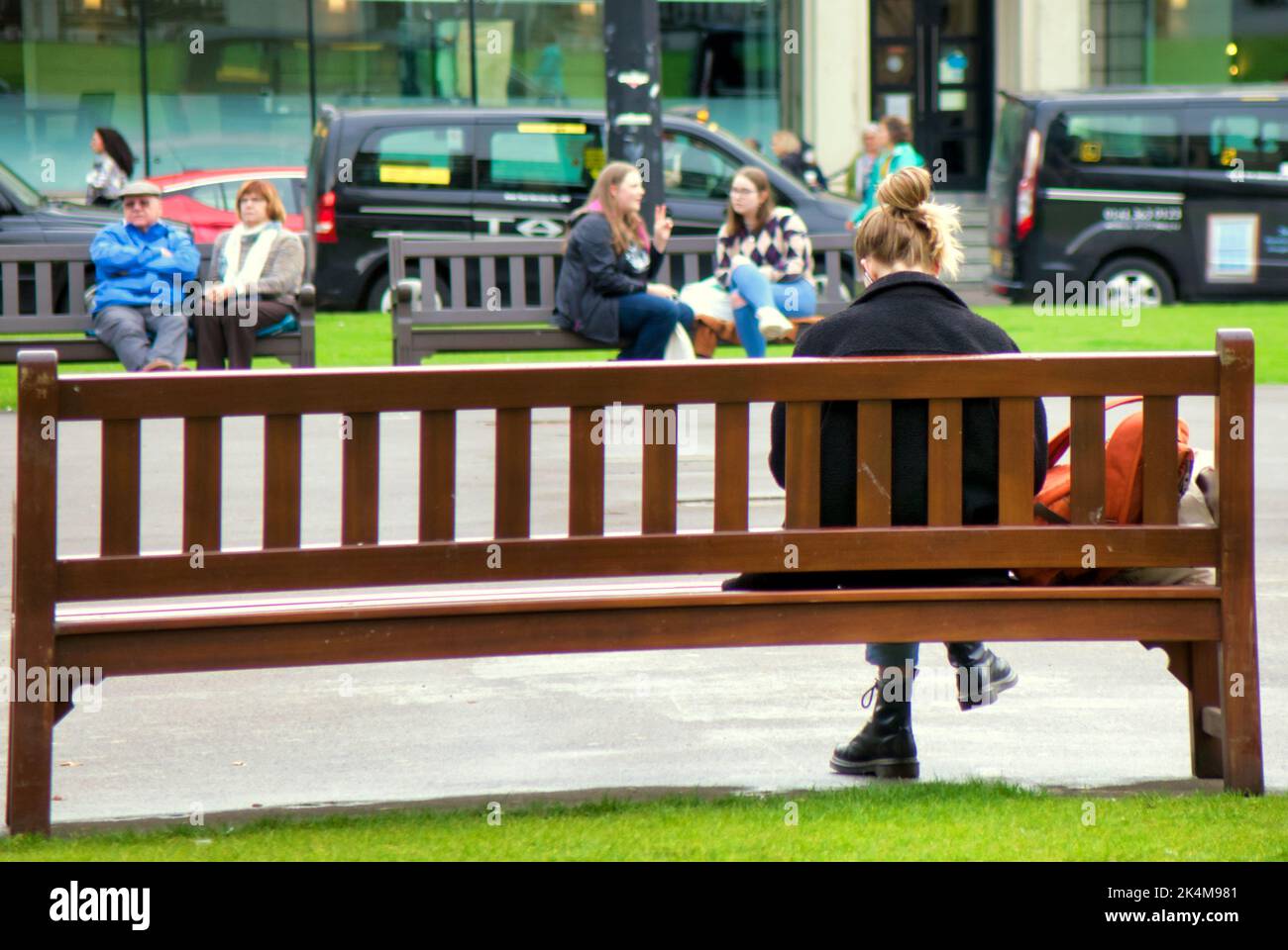 Jeune fille assise sur le banc à george Square Glasgow, Écosse, Royaume-Uni Banque D'Images