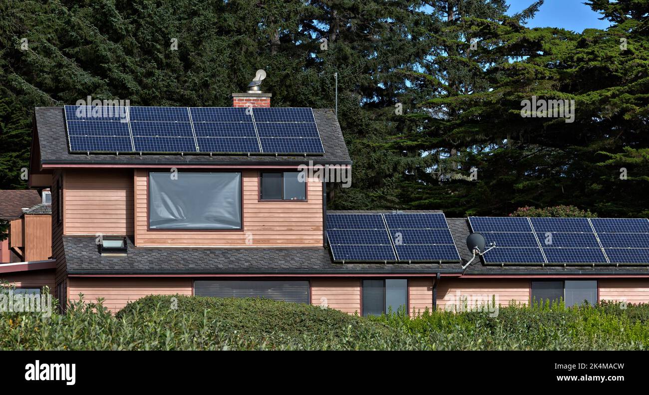 Panneaux solaires installés et fonctionnant sur le toit de la résidence, système d'énergie solaire, Sitka Spruce grove en arrière-plan, Californie. Banque D'Images