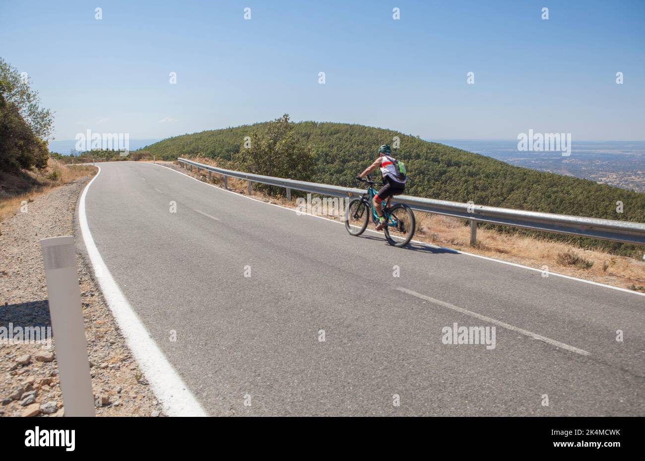 Cycliste senior qui accélère sur la route sinueuse du CC-139. Prise de vue à faible mouvement. Banque D'Images