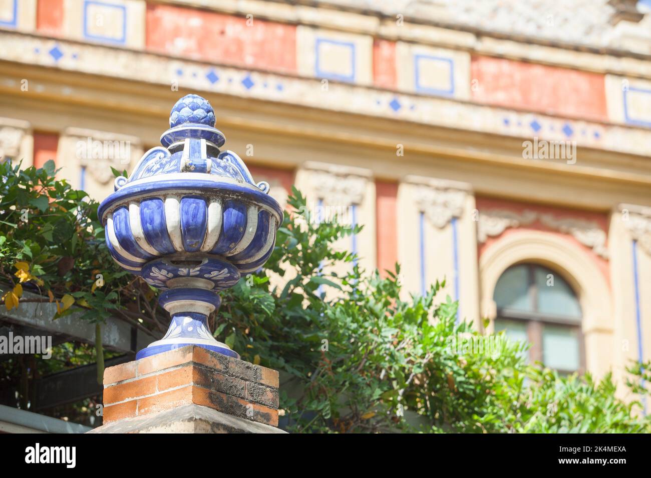 Vase haut en céramique coloré près du Palais de San Telmo, Séville, Andalousie, Espagne. Dessus de mur en brique. Banque D'Images