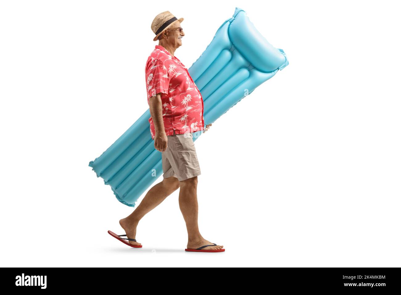 Photo pleine longueur d'un touriste mâle mature portant un matelas gonflable et marchant isolé sur un fond blanc Banque D'Images