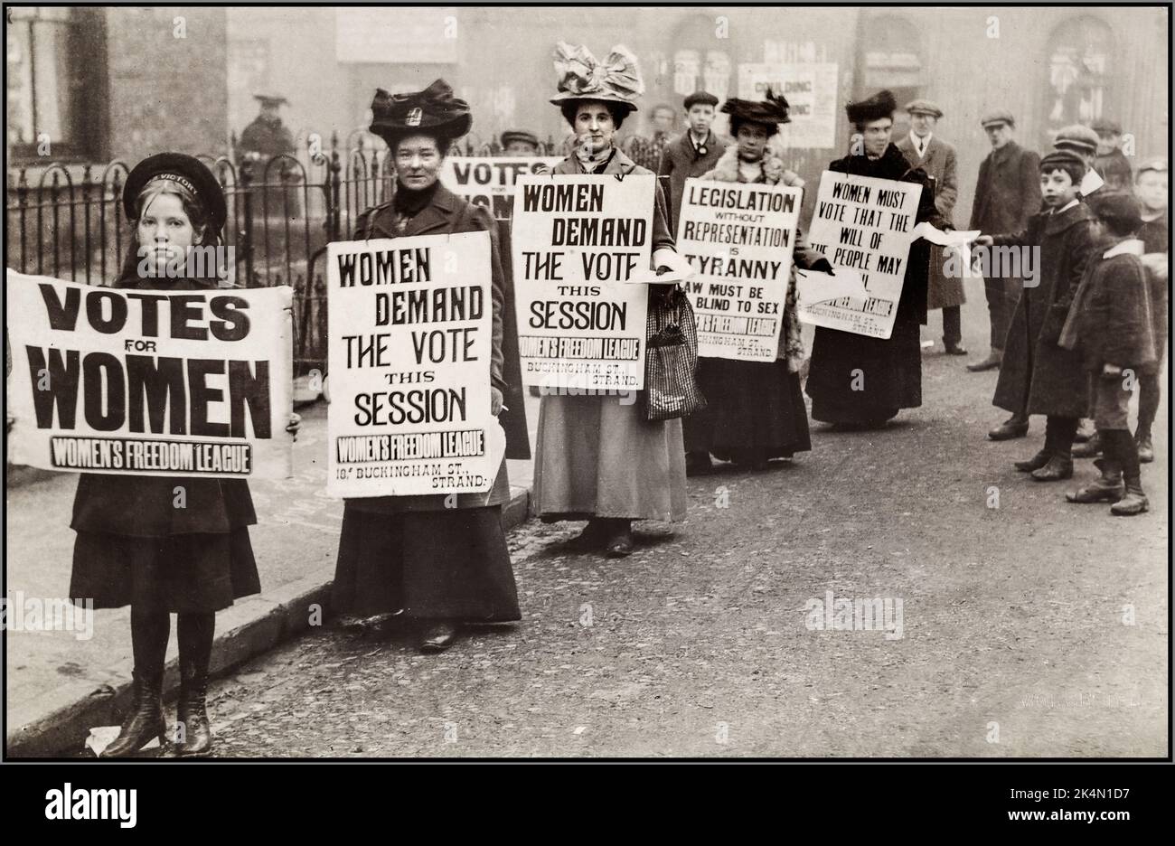 1900s mouvement des suffragettes les femmes avec des bannières réclamant «votes pour les femmes» Grande-Bretagne suffrage manifestation de rue avec des bannières et de jeunes enfants interagissant et aidant avec des manifestants et des suffragettes UK ‘ LES FEMMES DEMANDENT LE VOTE’ ''Women'Freedom League' Banque D'Images