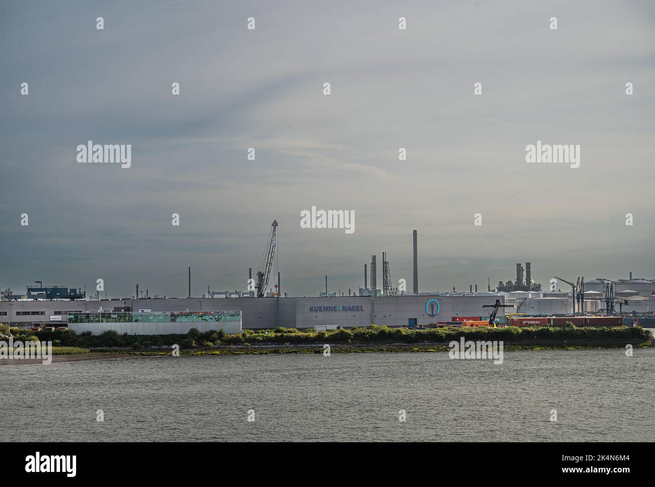 Rotterdam, pays-Bas - 11 juillet 2022: Kuehne+Nagel Logistics builidngs at 2nd Petroleumhaven sous ciel de soirée épaississant avec chars et cheminées ar Banque D'Images