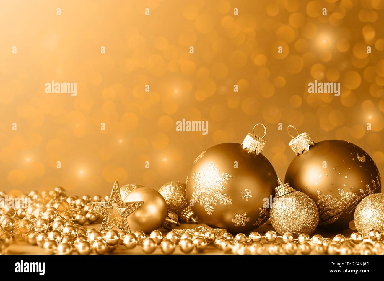 Boules de Noël dorées sur paillettes avec lumières défoquées sur fond, carte de vœux du nouvel an Banque D'Images