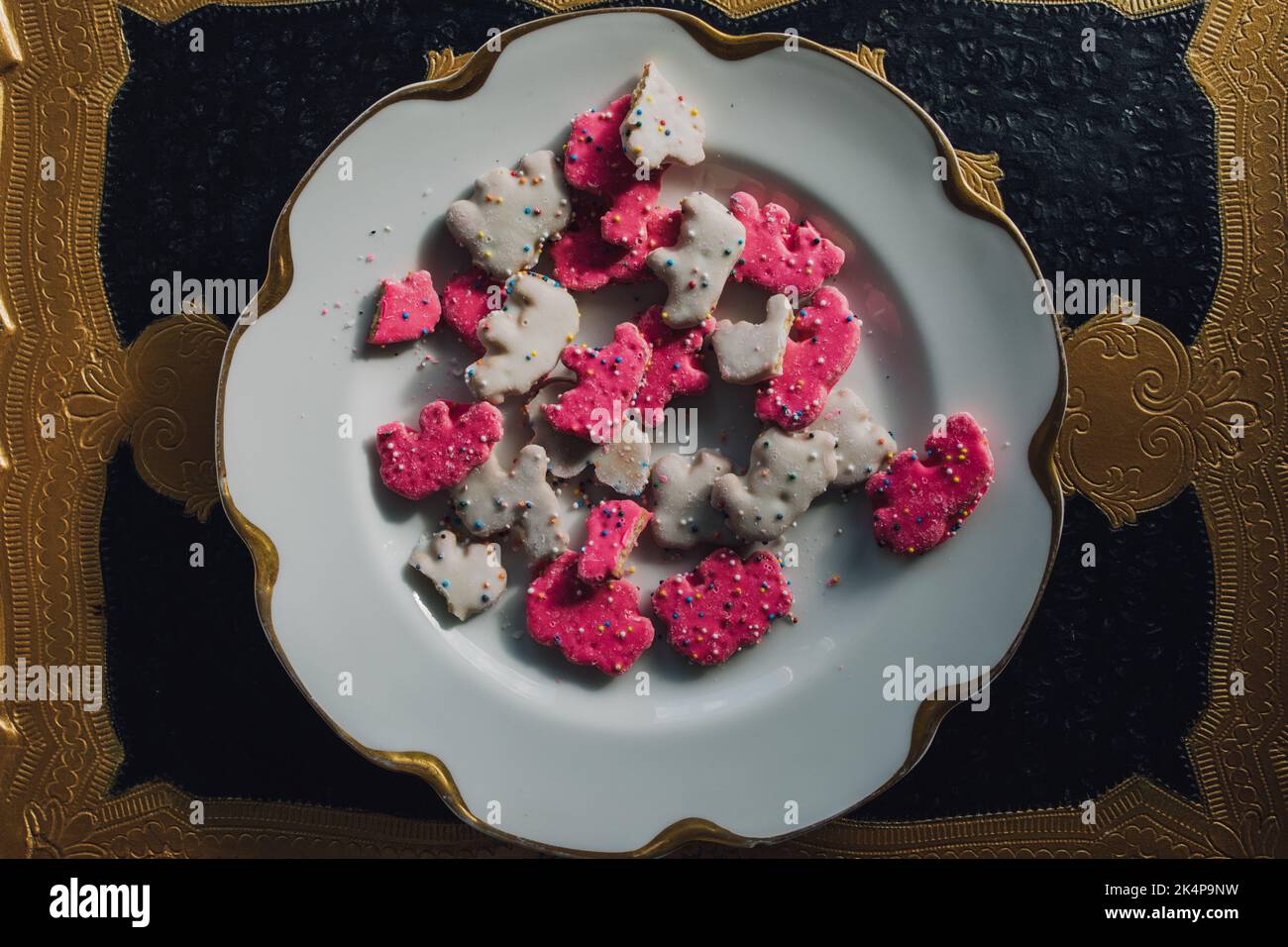 Biscuit à l'animal de cirque dépoli Rose et blanc biscuits secs à l'animal saupoudrés sur une assiette blanche Banque D'Images