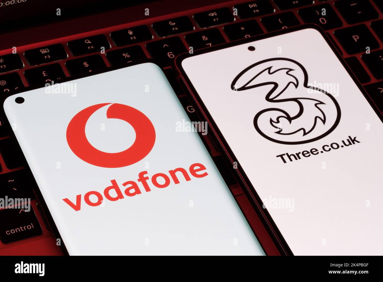 Vodafone et trois potentiels de fusion concept. Les smartphones vus avec les logos des opérateurs mobiles britanniques sur les écrans. Stafford, Royaume-Uni, OC Banque D'Images