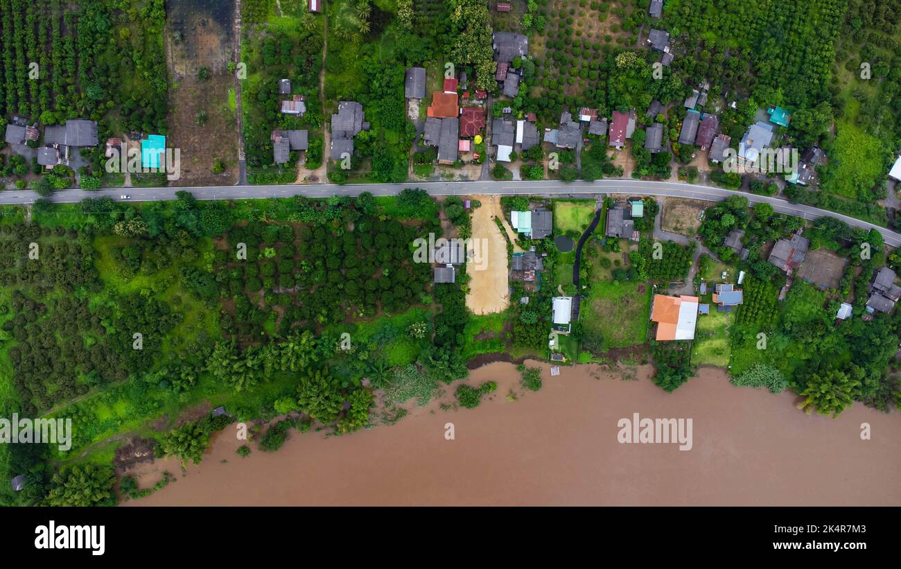 Vue aérienne de la rivière qui coule après de fortes pluies et des inondations dans les villages ruraux. Vue de dessus des zones agricoles touchées par la saison des pluies fl Banque D'Images