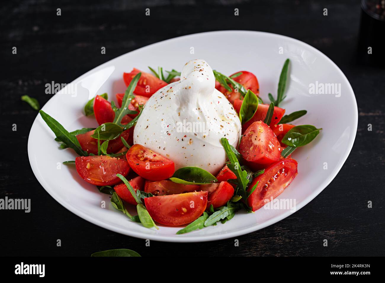 Salade avec tomates et fromage burrata avec basilic et huile d'olive sur l'assiette. Cuisine italienne. Banque D'Images