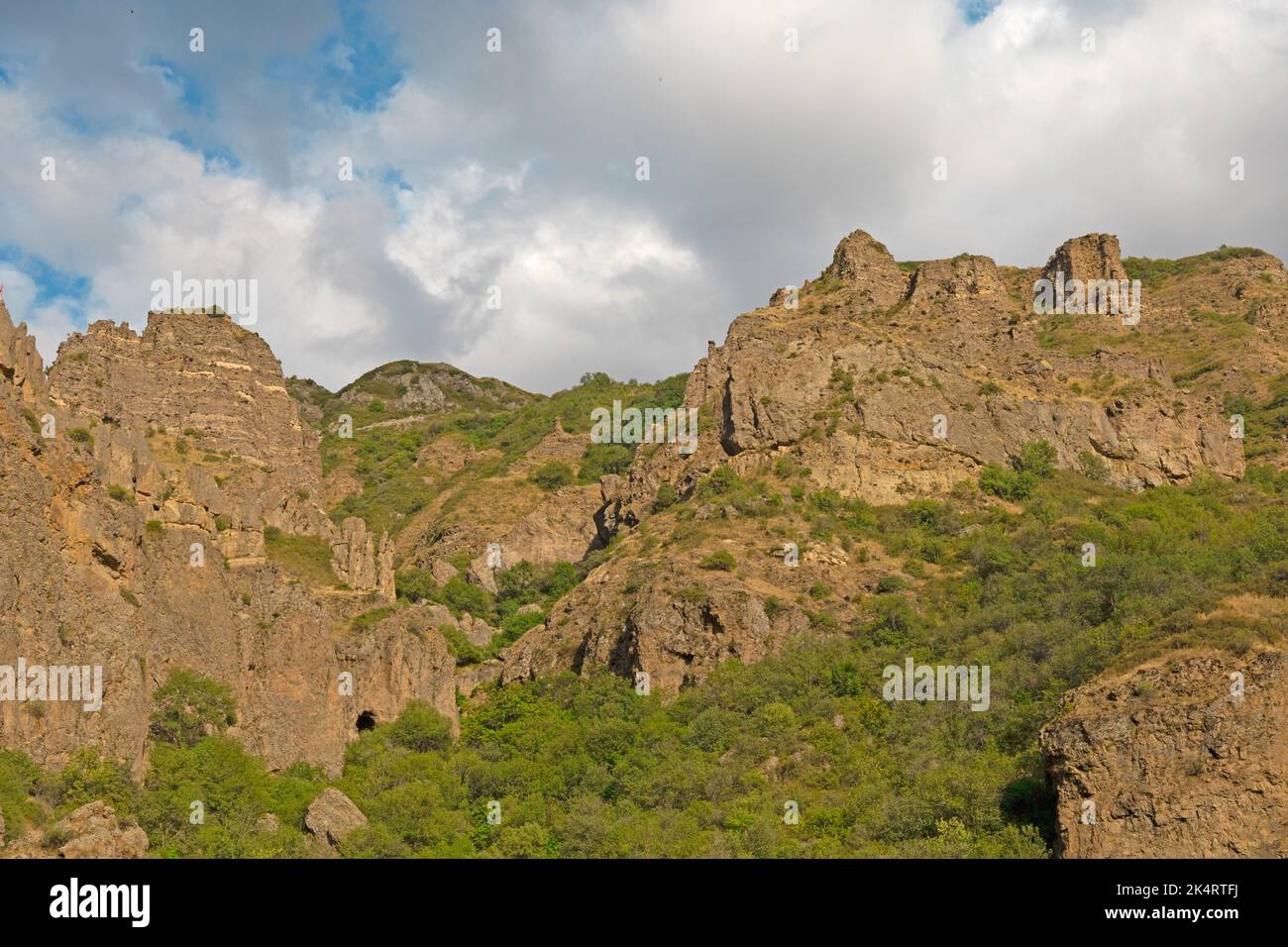 Montagnes rocheuses et boisées près du monastère de Geghard, par une journée ensoleillée et nuageux, au coucher du soleil, pendant l'heure d'or Banque D'Images