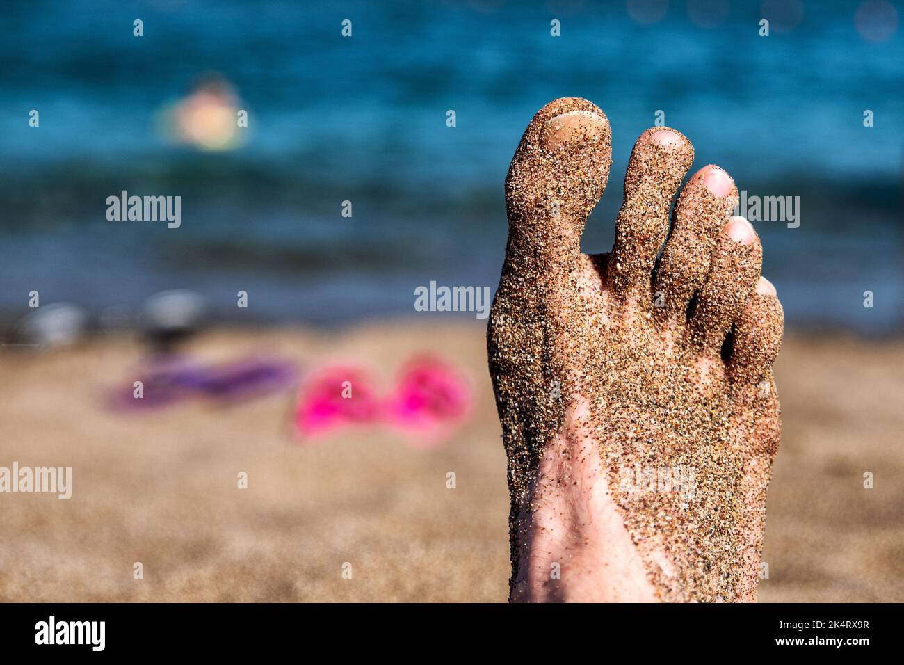Détendez-vous sur la plage de sable. Sable sur la jambe de l'homme. Concept de vacances d'été Banque D'Images