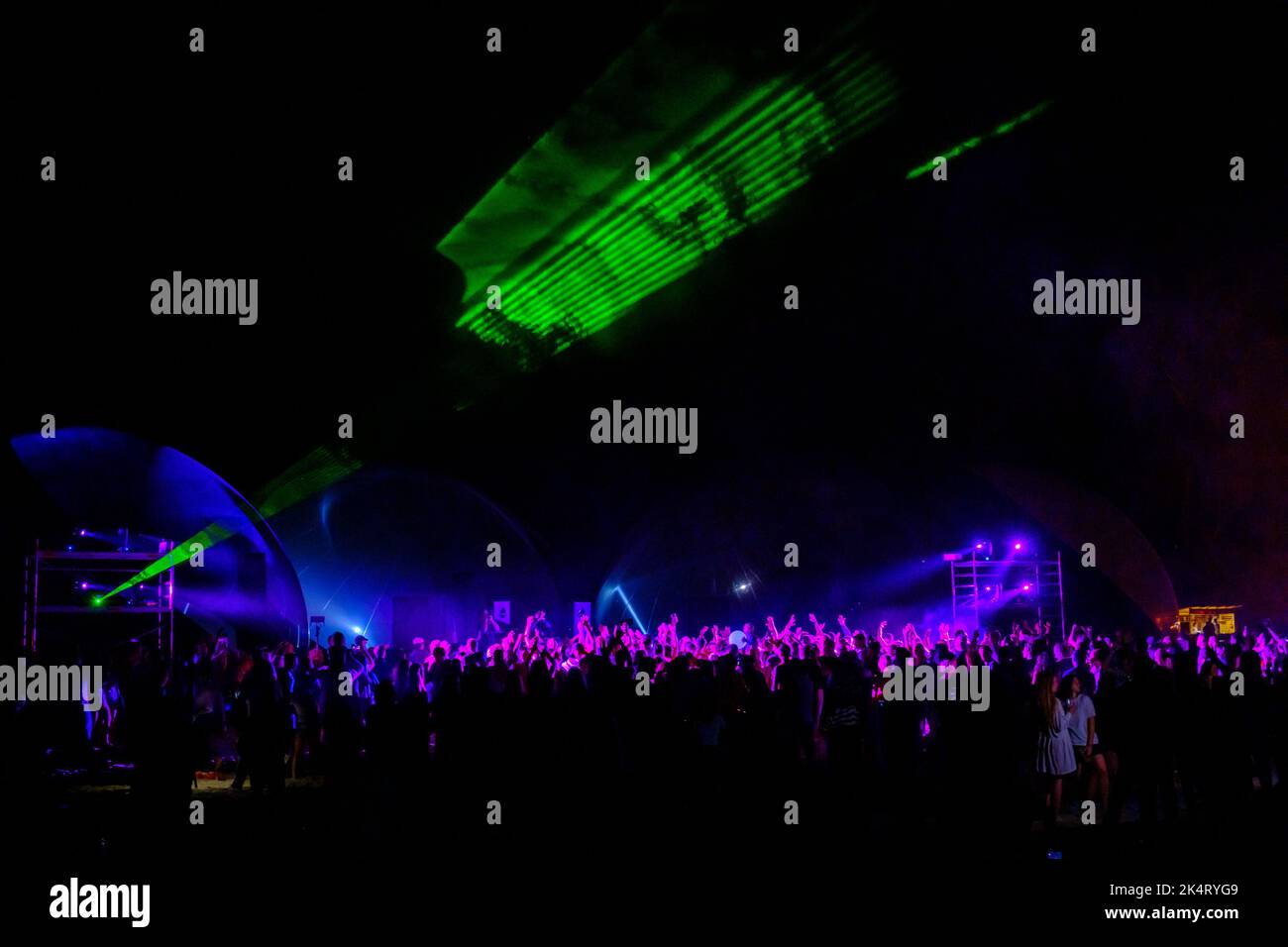 Des lumières laser colorées brillent et se déplacent sur la foule dansante pendant la fête du DJ Banque D'Images