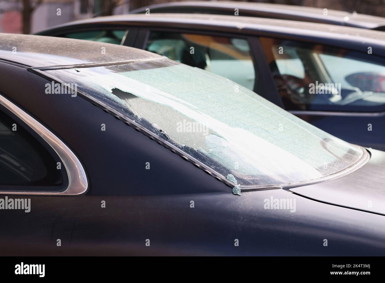 Vitre arrière cassée d'une voiture noire dans la rue, gros plan Banque D'Images