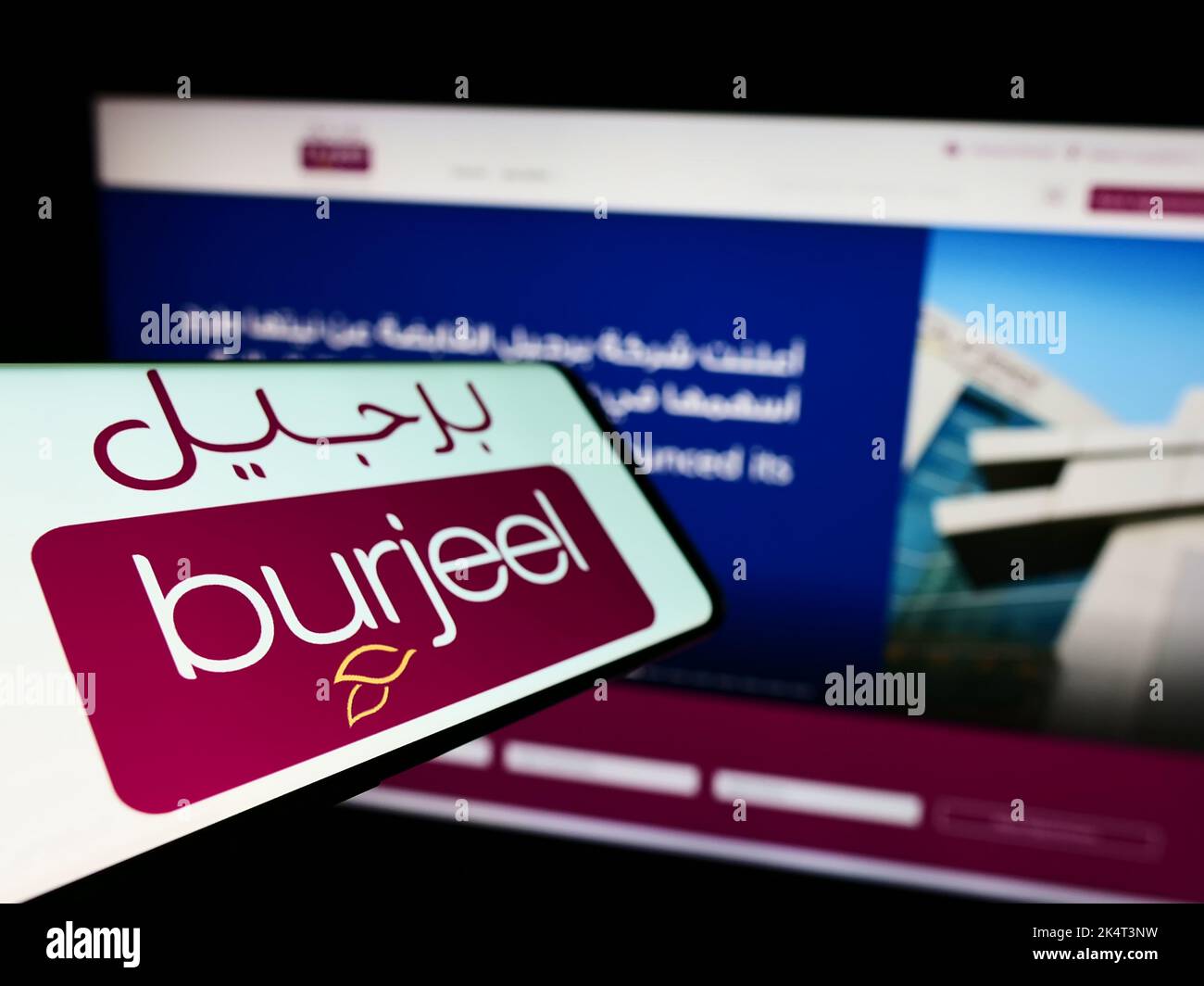 Téléphone portable avec logo de l'opérateur de l'hôpital Emirati Burjeel à l'écran en face du site Web d'affaires. Mise au point à gauche de l'écran du téléphone. Banque D'Images